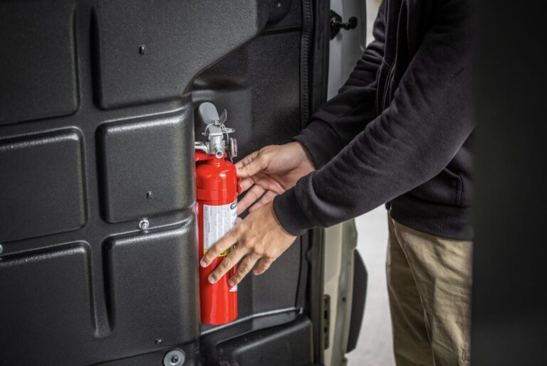 Person pulling truck safety accessories out of a work truck.
